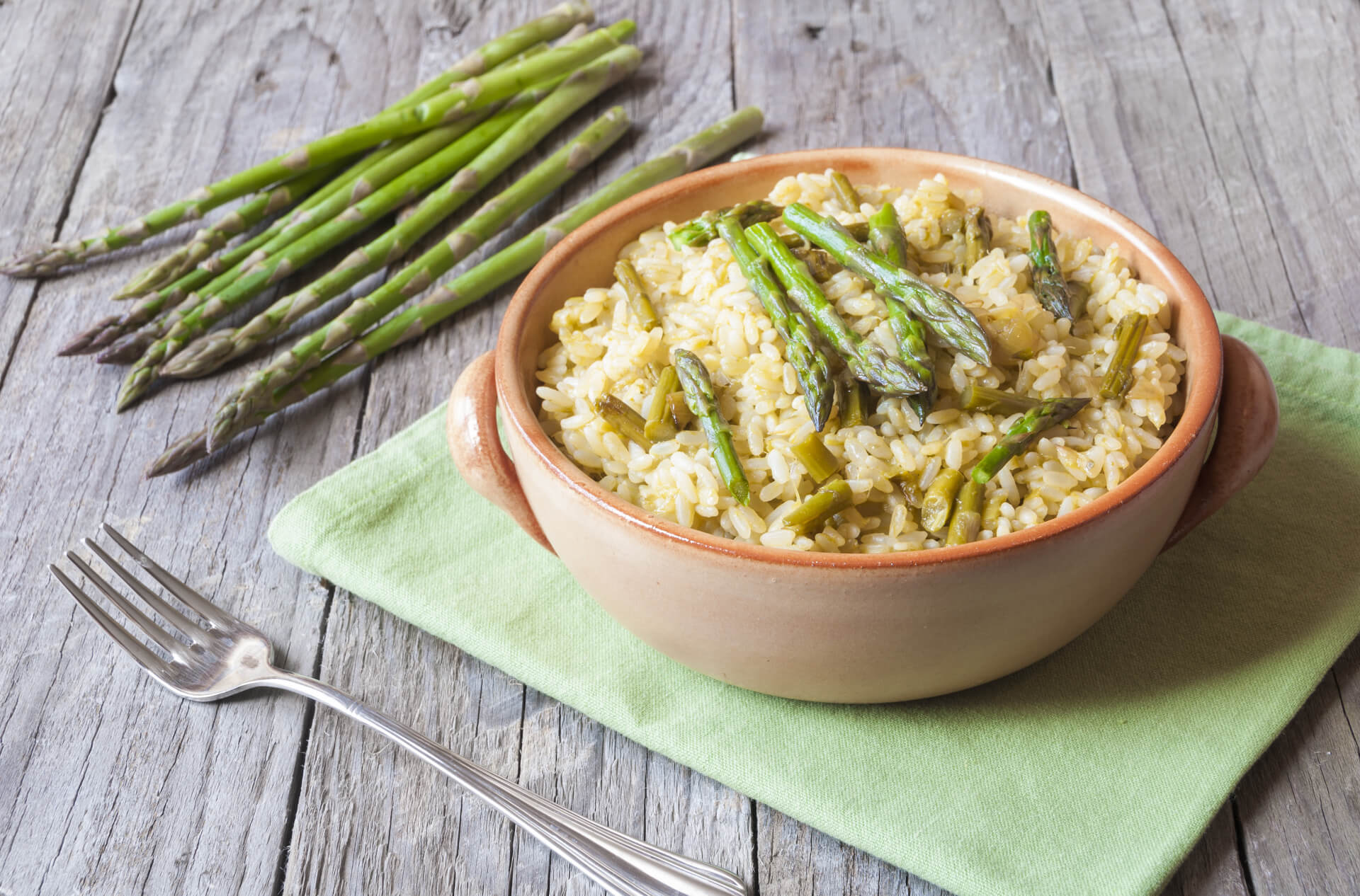 Spargelrisotto in einer Schale mit Serviette und Gabel