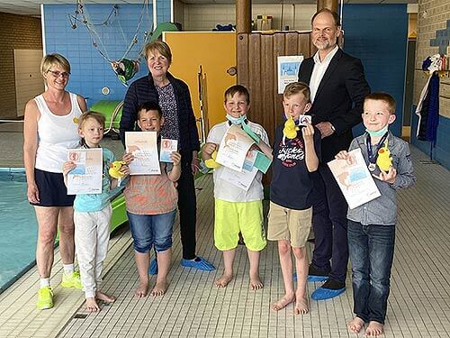 Kinder mit Urkunden im Schwimmbad