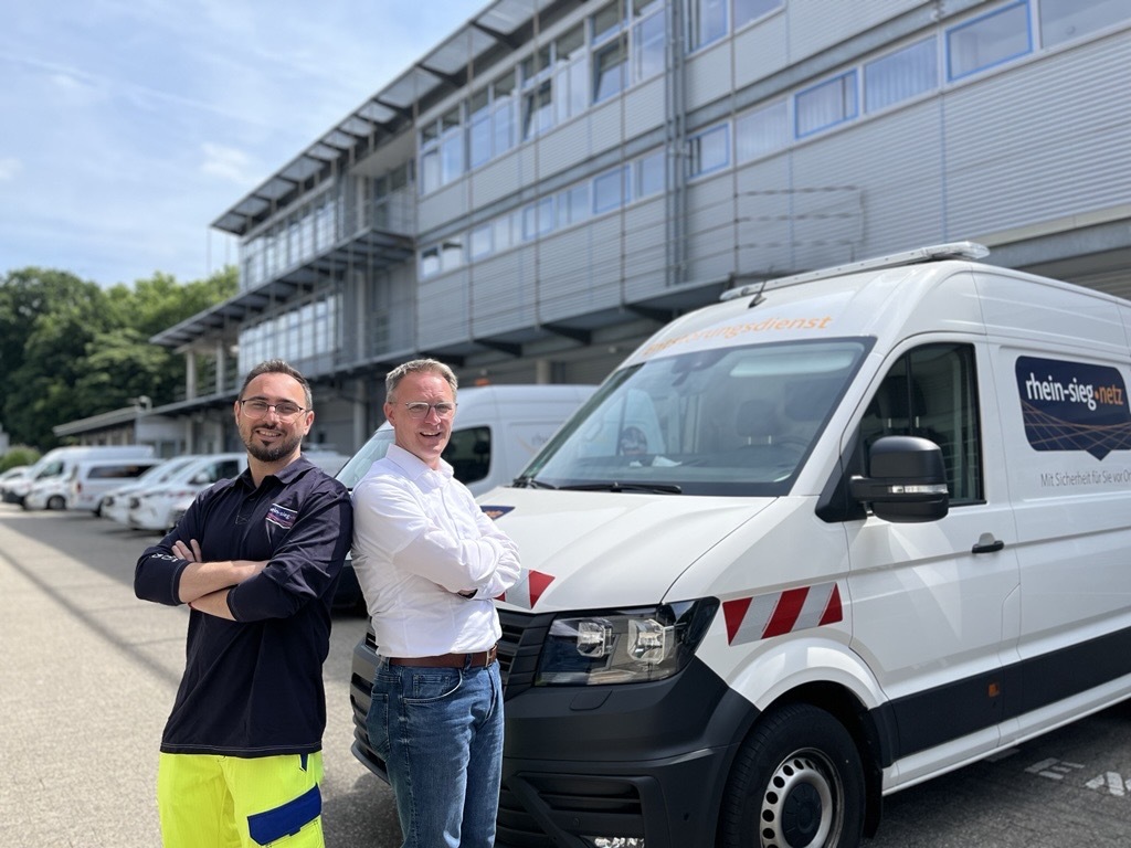 Laurentiu von Rhein-Sieg Netz und Thomas von rhenag Energie stehen vor einem Rhein-Sieg-Netz-Transporter.
