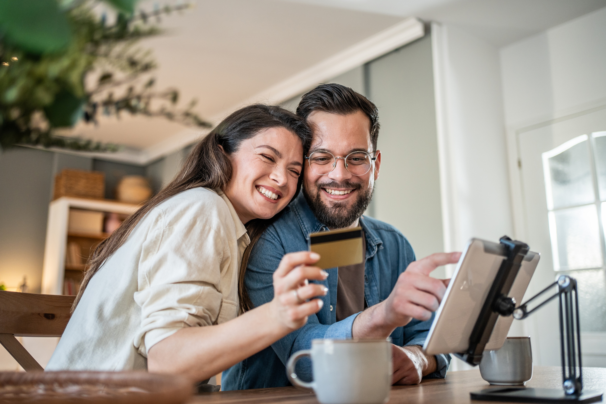 Ein junges Paar kauft online etwas mit der Kreditkarte.