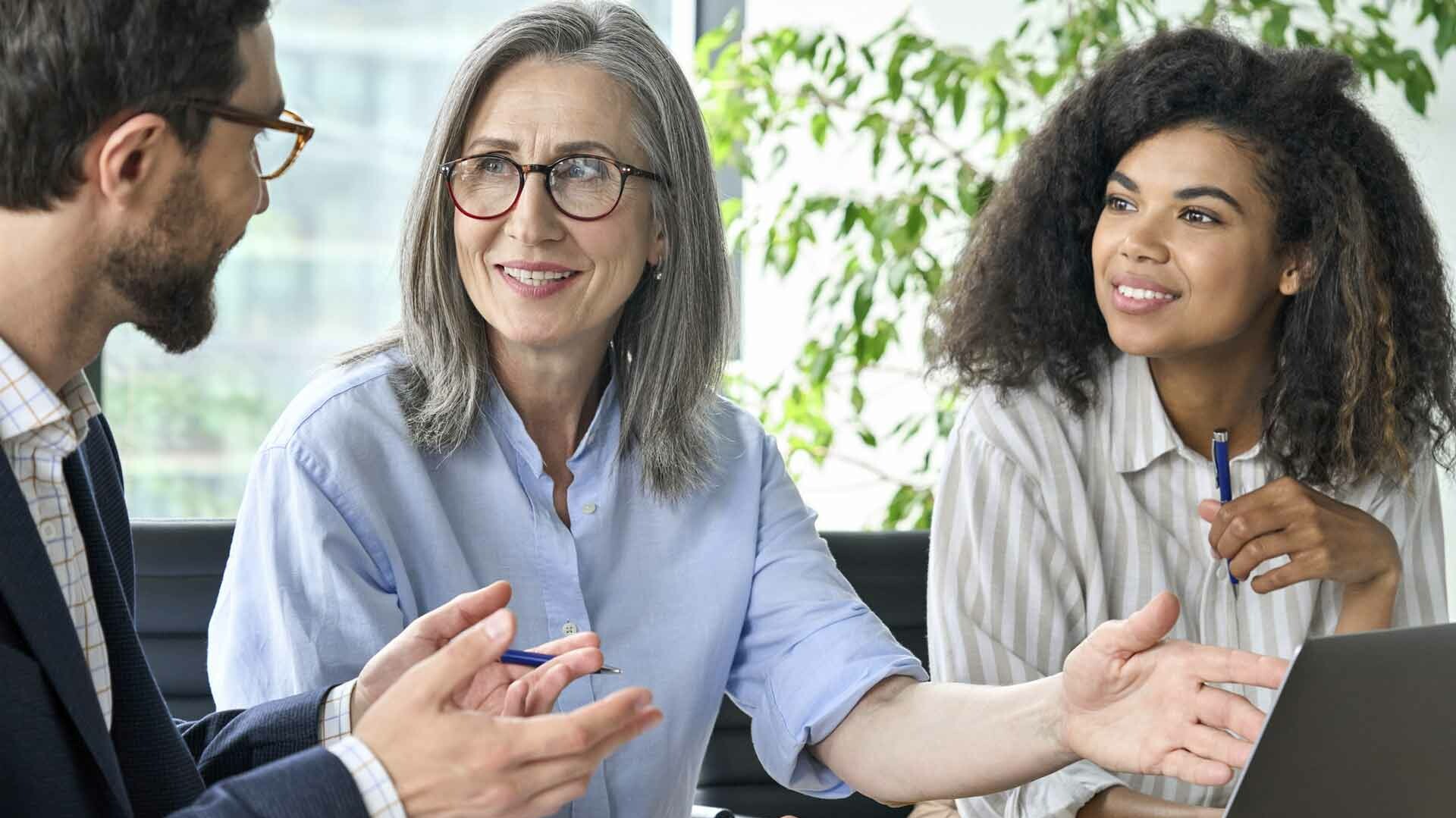 Ein Mann und zwei Frauen sprechen miteinander.