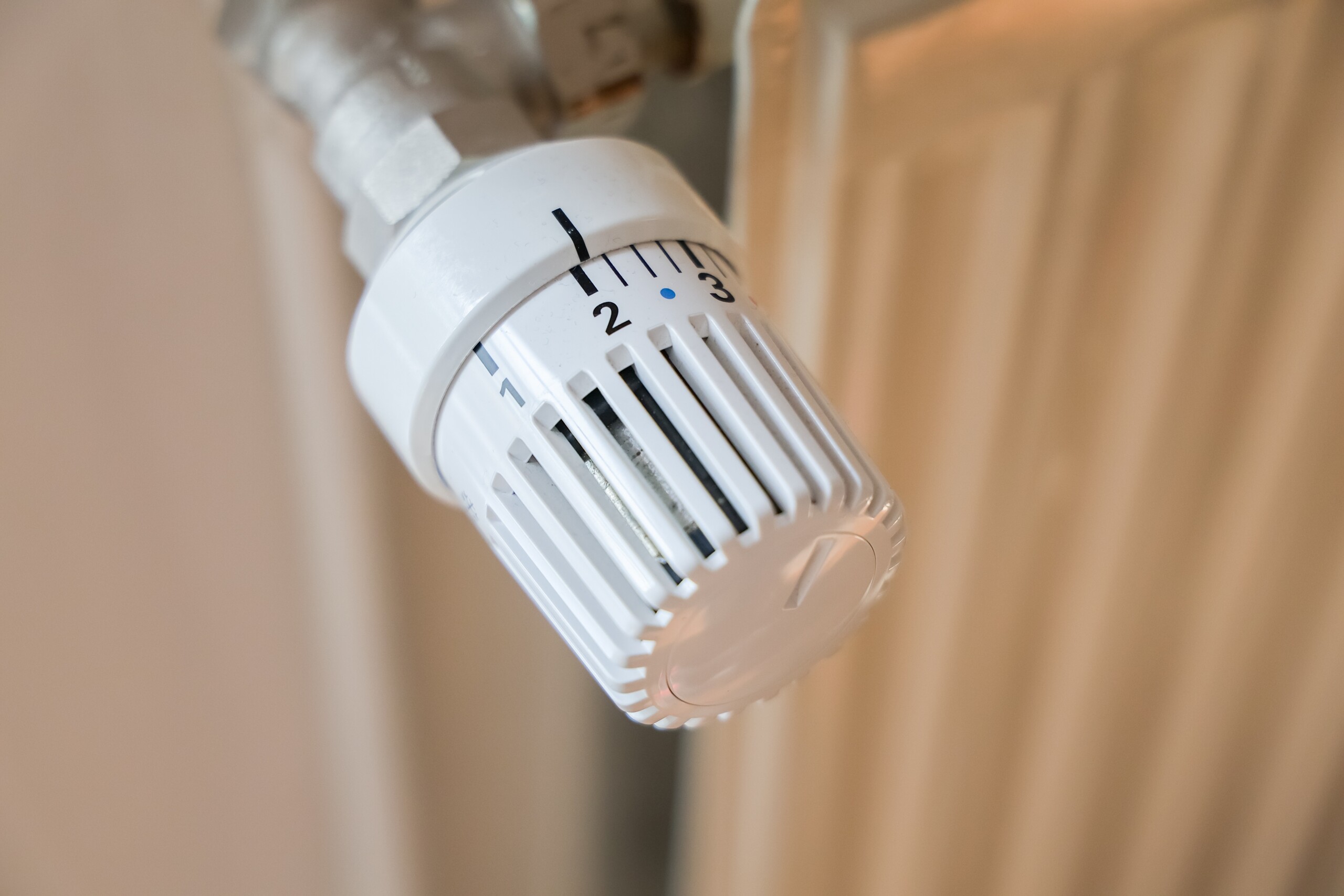 Ein digitales Thermostat an einer Heizung in einer Wohnung reguliert die Temperatur.