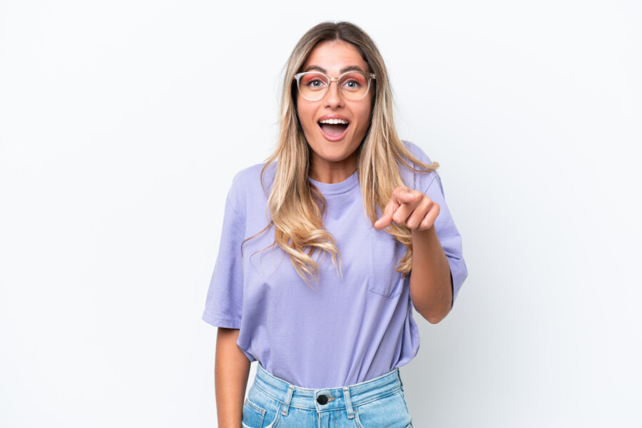 Junge Frau mit blauem Hemd und Brille schaut mit nachdenklicher Miene nach oben.