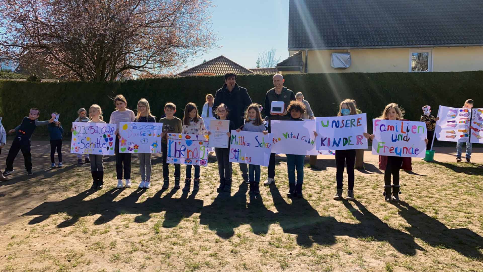 Schulkinder mit Plakaten auf dem Hof