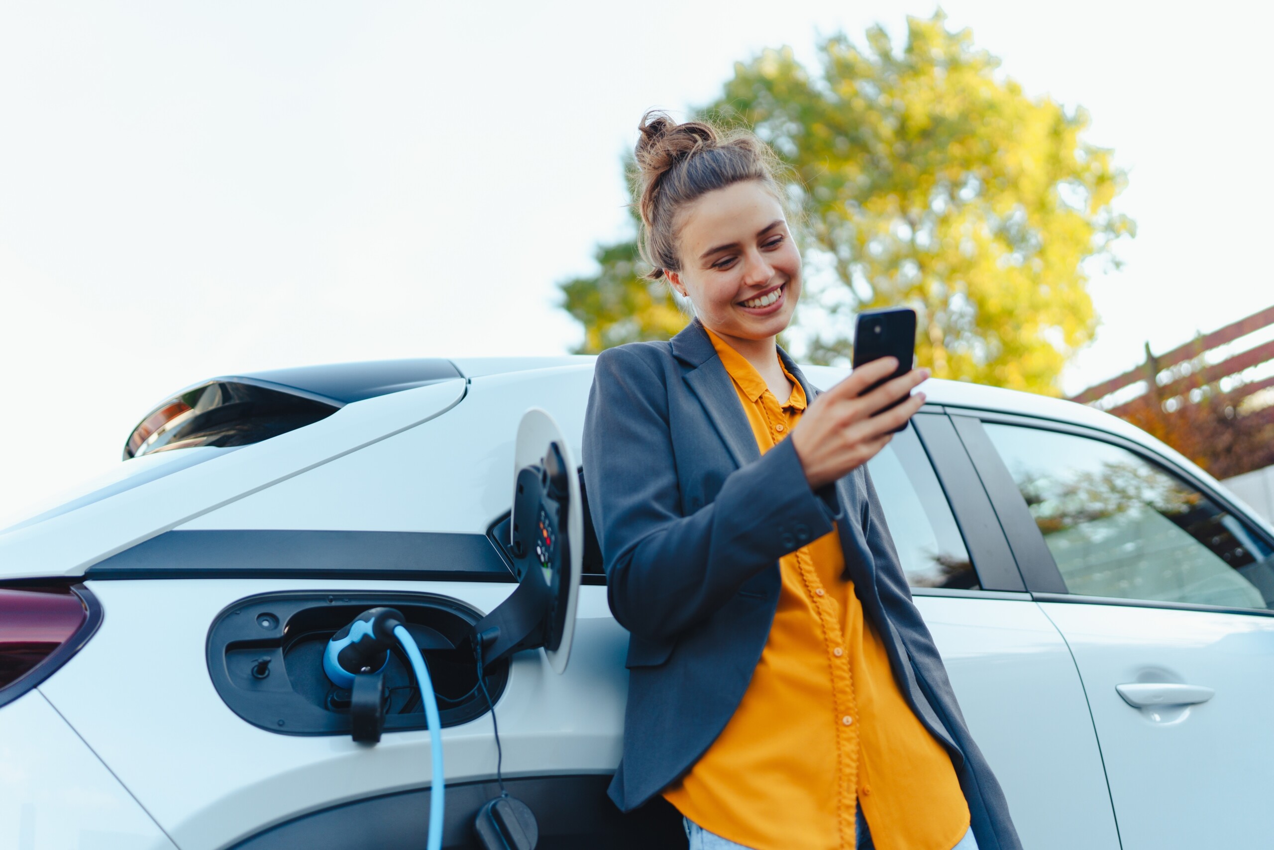 Frau lädt E-Auto