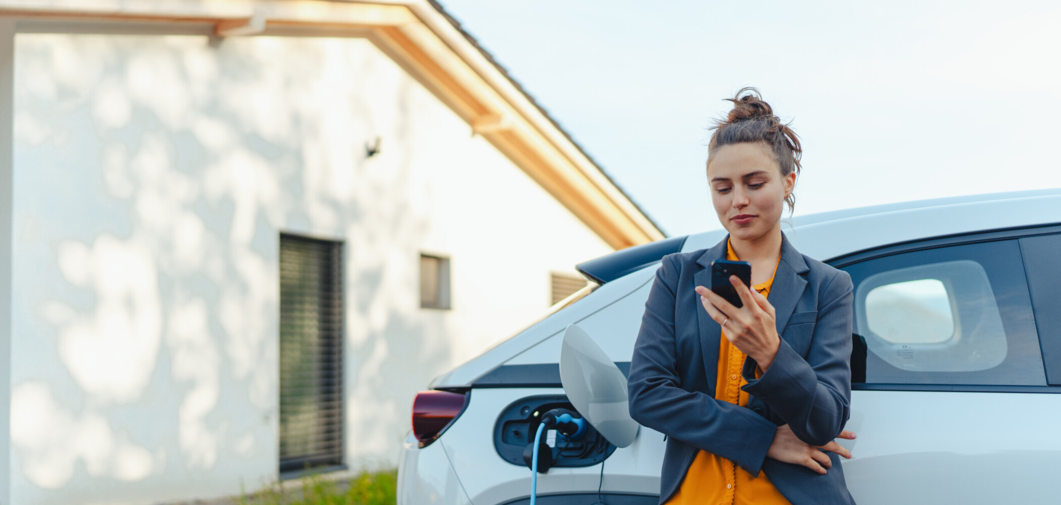 Frau lädt E-Auto